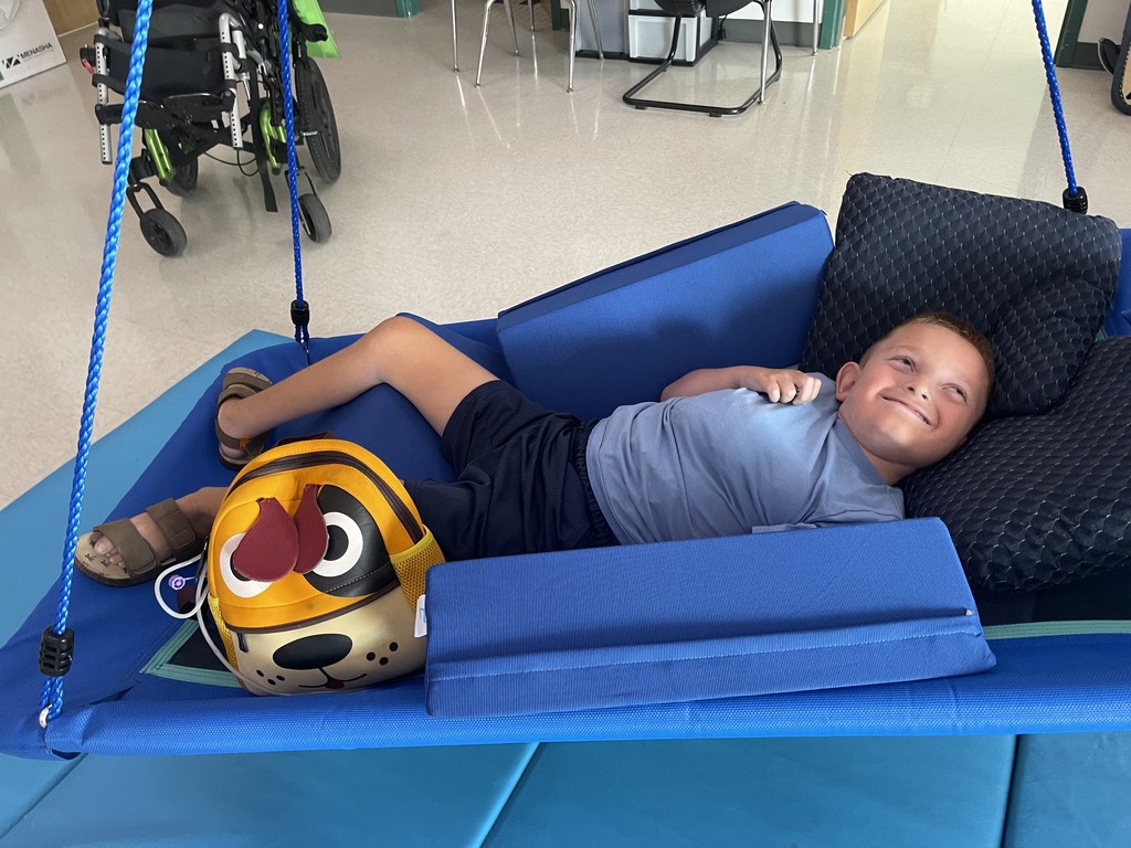 An elementary student in a lay down swing.