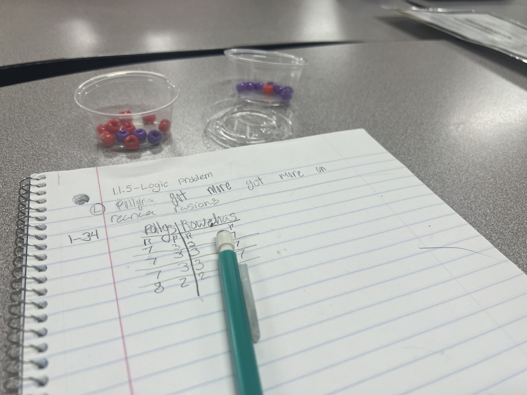 A picture of a notebook and little cups with beads that were used to replicate a larger experiment.
