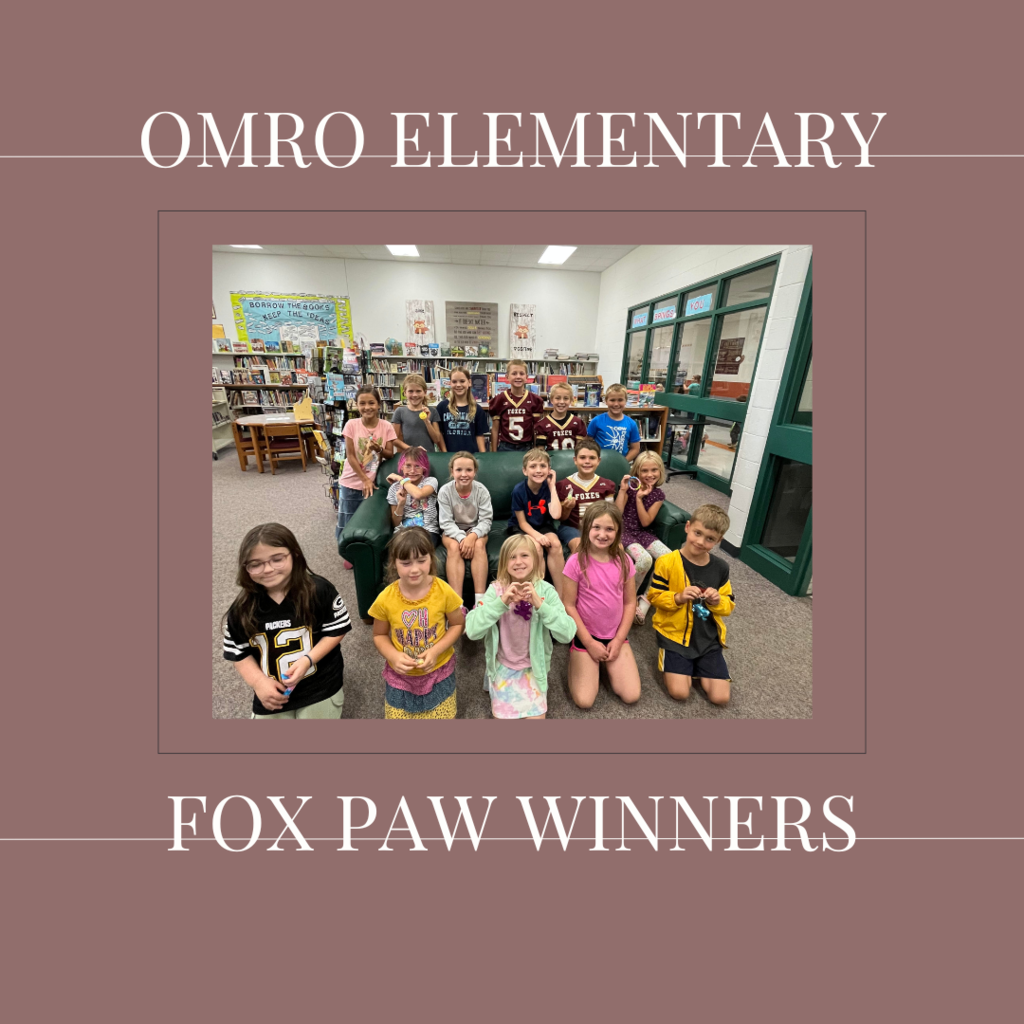 A group of elementary students standing in a media center.
