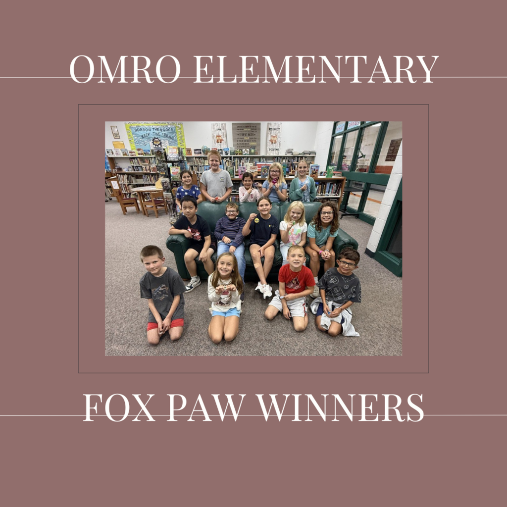 A group of elementary students standing in a media center.