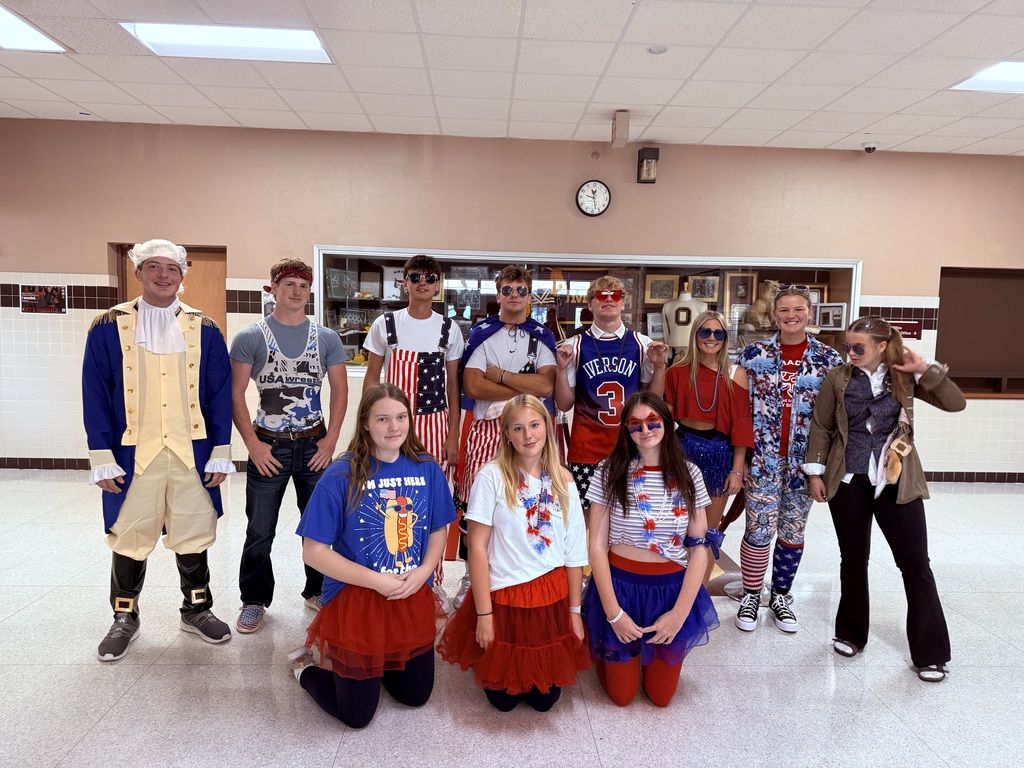 High school students, wearing red, white, and blue, stand together for a photo.
