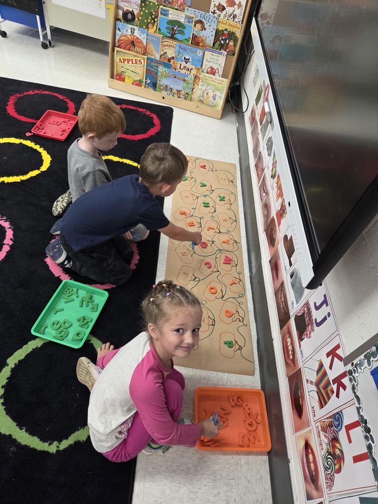 Three early learners working on letter matching.
