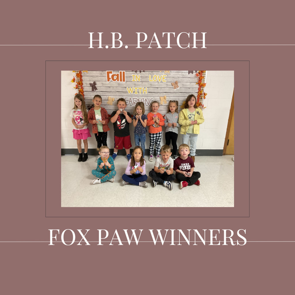 A group of early elementary students standing in front of a bulletin  board.