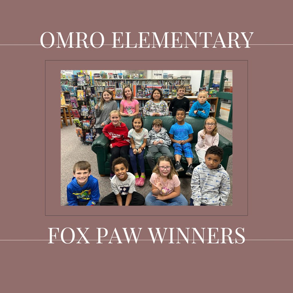 A group of elementary students standing in a media center.