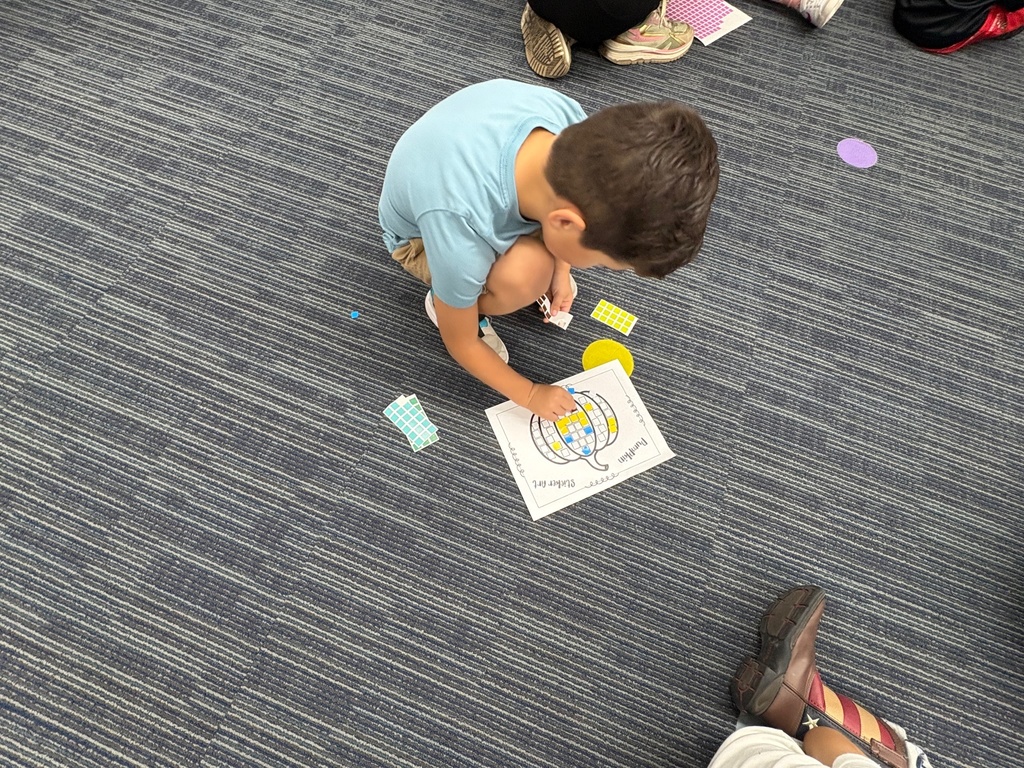 Early learner completing sticker art in the media center.