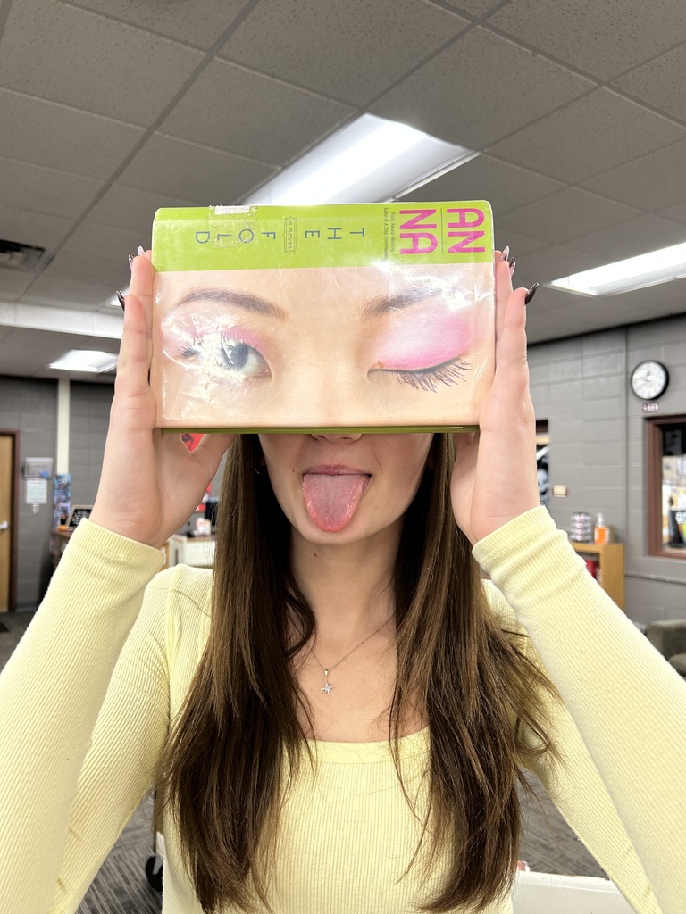 A "book face" picture of a person posing with a book to make it look like they are a part of the cover.