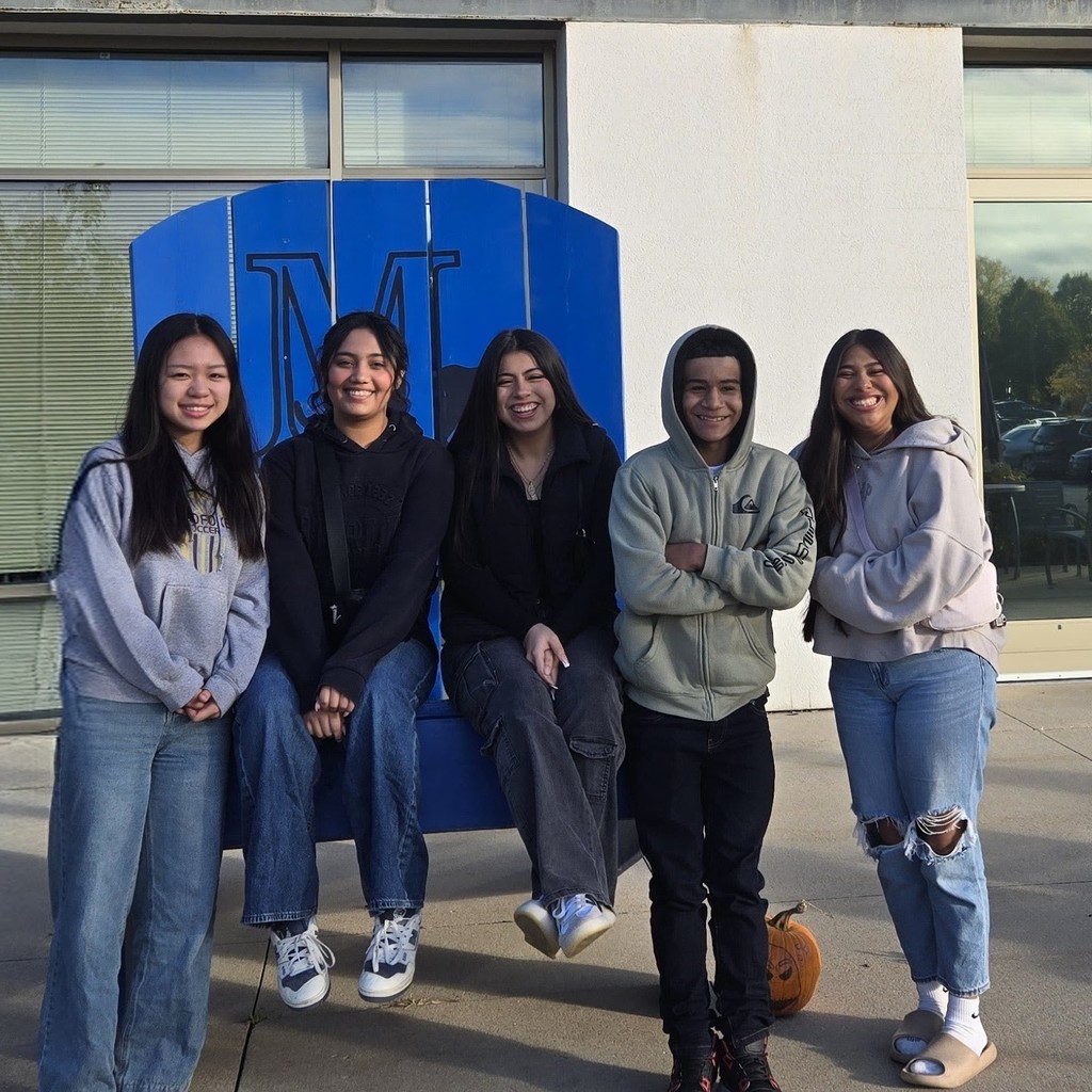 5 high school students standing around, smiling and looking at the camera.