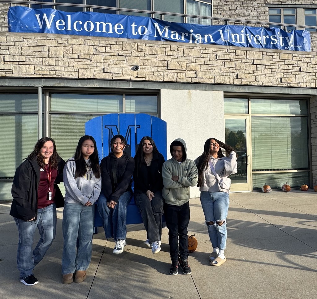 5 high school students and a teacher standing in front of Marian University. 