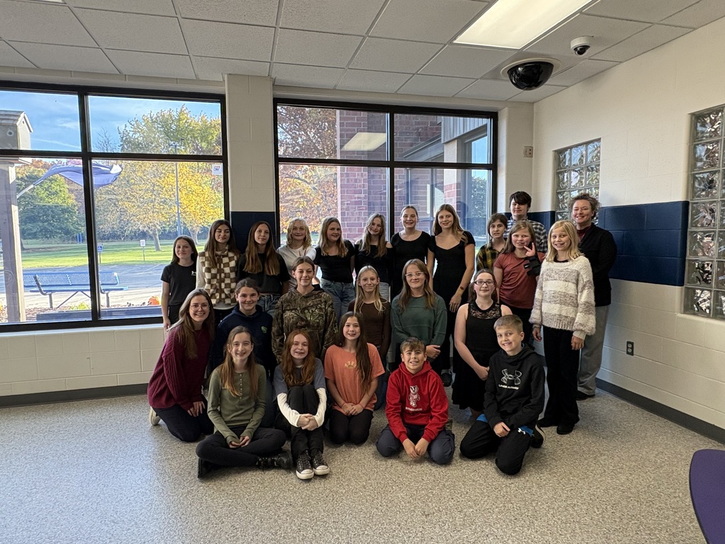 A group of students and their teacher standing together.