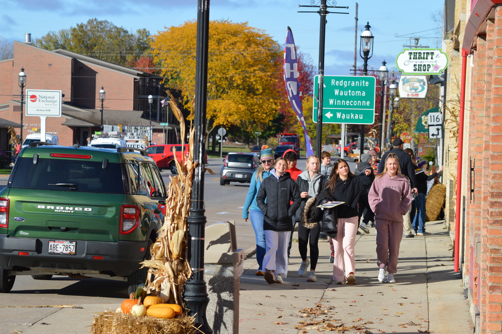 A group of middle school students walking outside on a fall day.