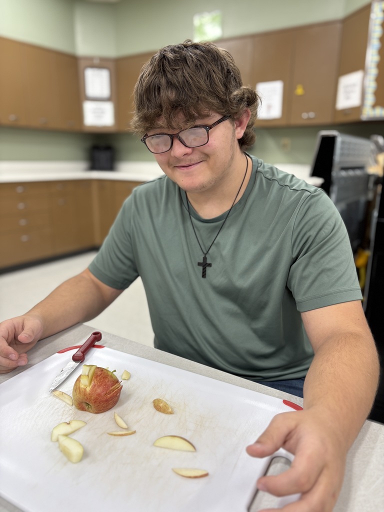A student presenting fruit that is delicately sliced.