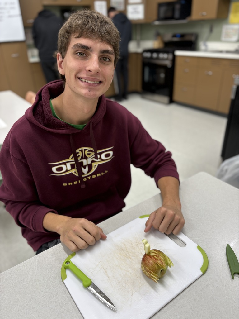 A student presenting fruit that is delicately sliced.