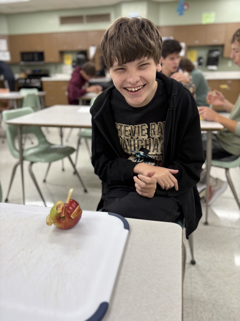 A student presenting fruit that is delicately sliced.