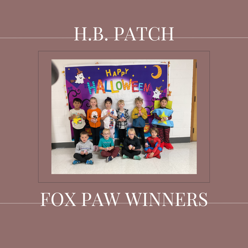 A group of early elementary students standing in front of a bulletin  board.