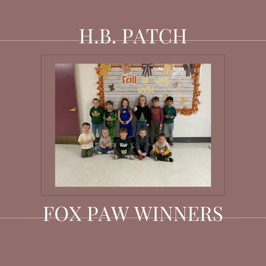 A group of early elementary students standing in front of a bulletin board.