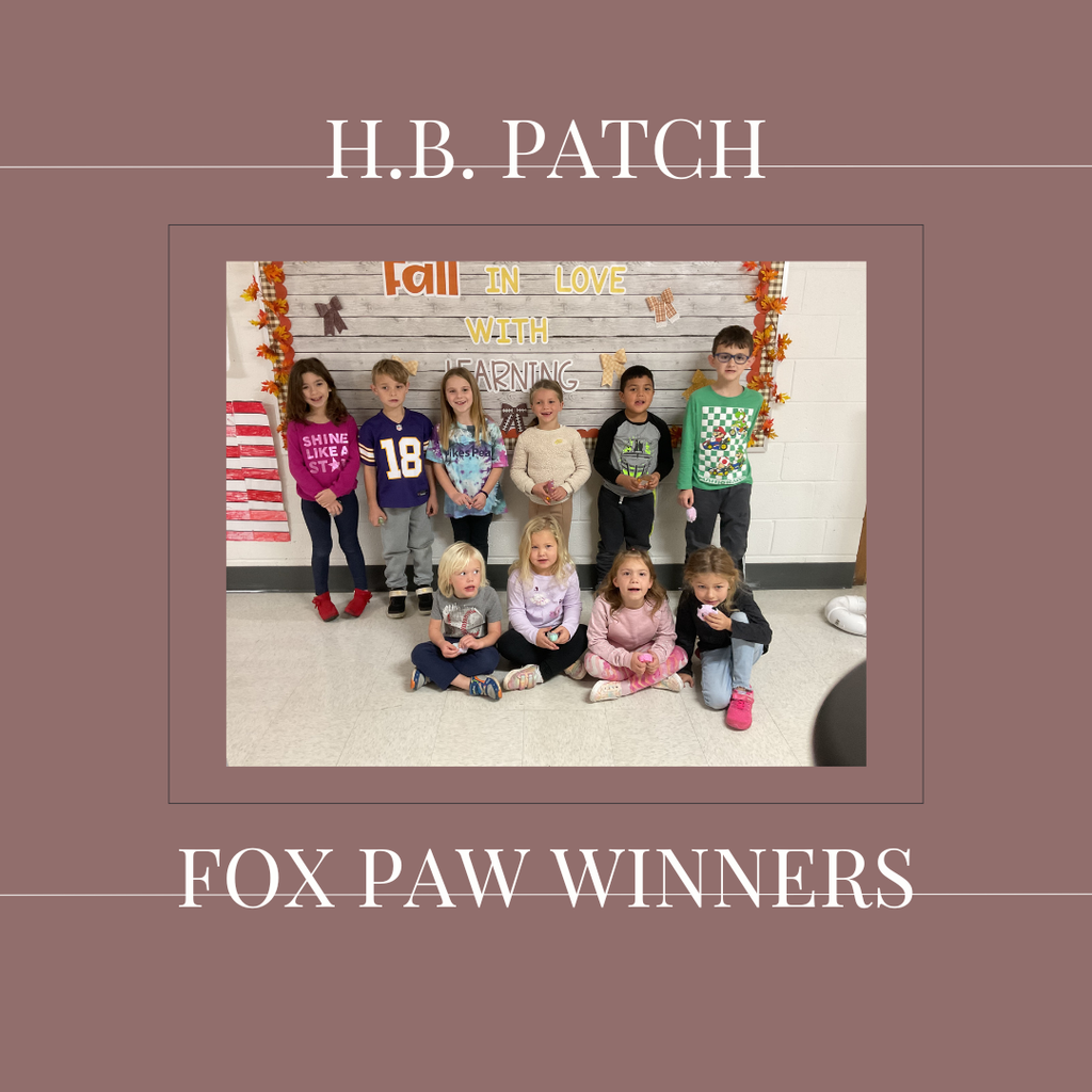 A group of early elementary students standing in front of a bulletin board.