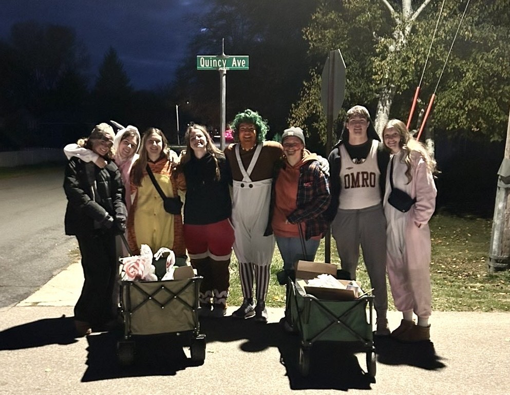 High school students trick or treating for canned goods.