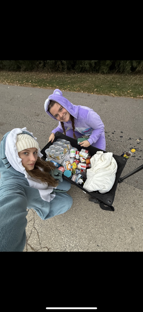 High school students trick or treating for canned goods.