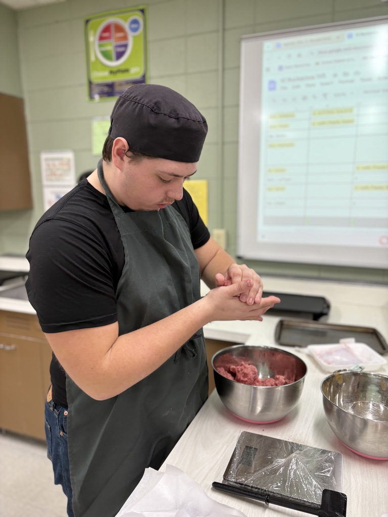 A high school st udent making hamburgers.