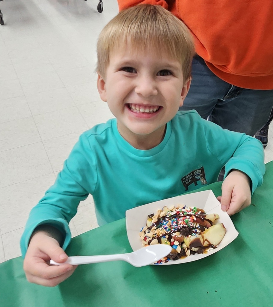 A student enjoying a cut up caramel apple with toppings.