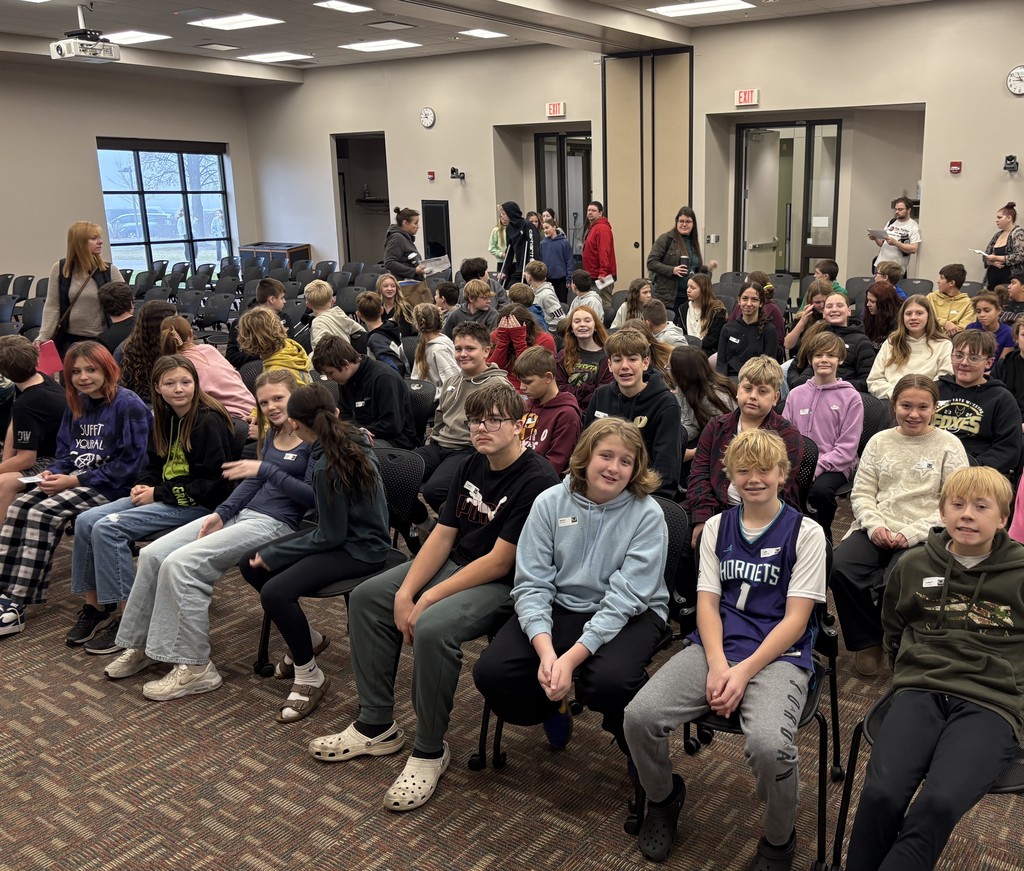 A group of students sitting in chairs in a classroom setting. 