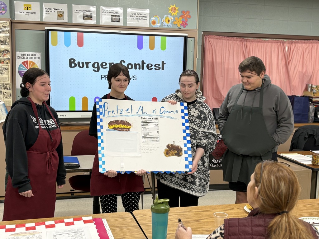 High school students presenting a poster in front of a class.