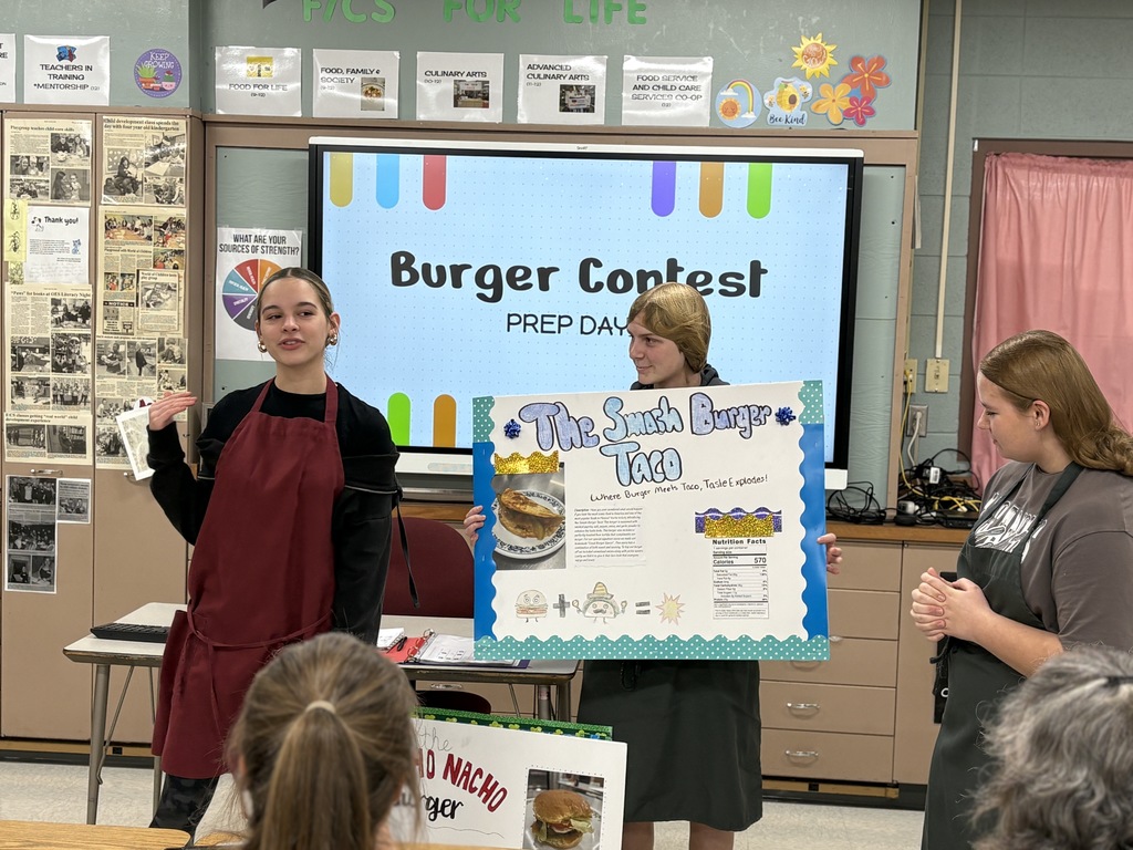 High school students presenting a poster in front of a class.