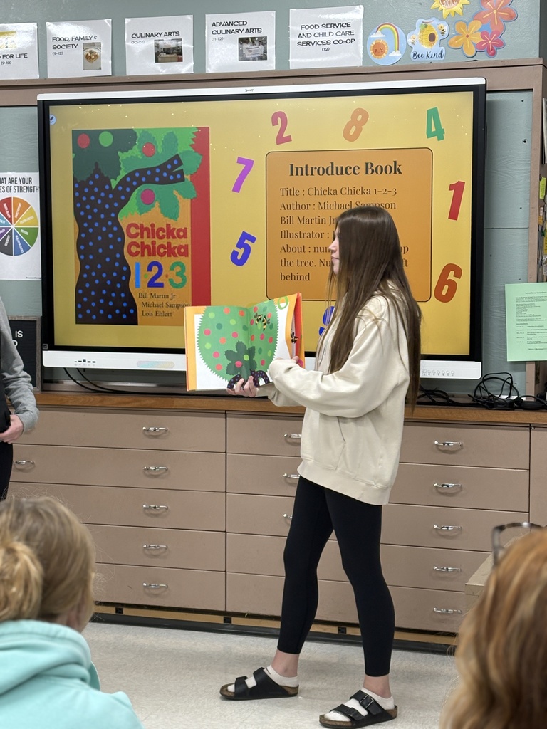 A high school student reading a children's book aloud.