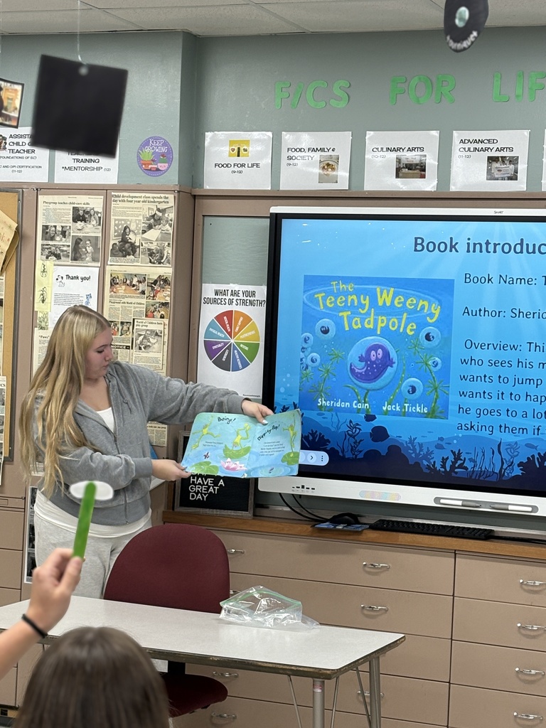 A high school student reading a book aloud. 