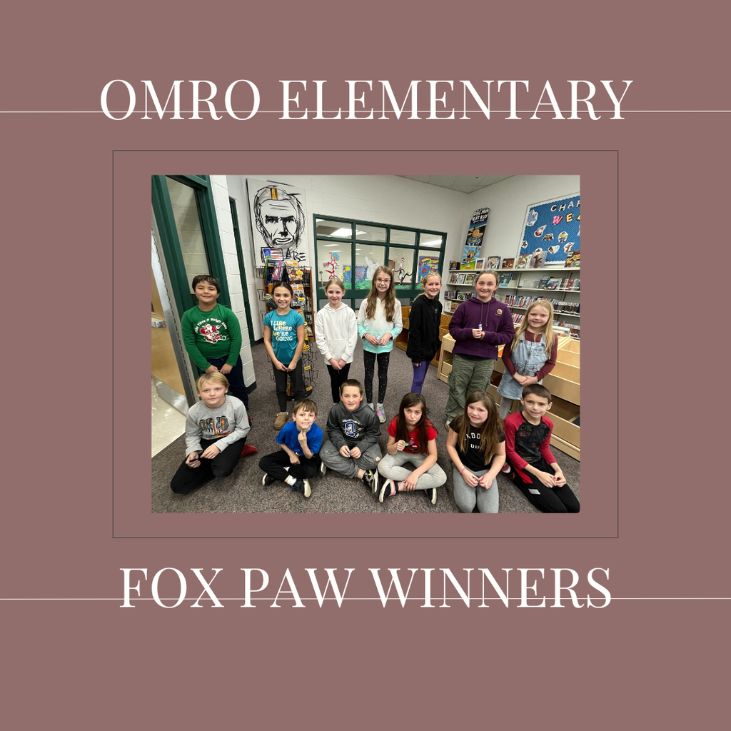 A group of elementary students standing in a media center.