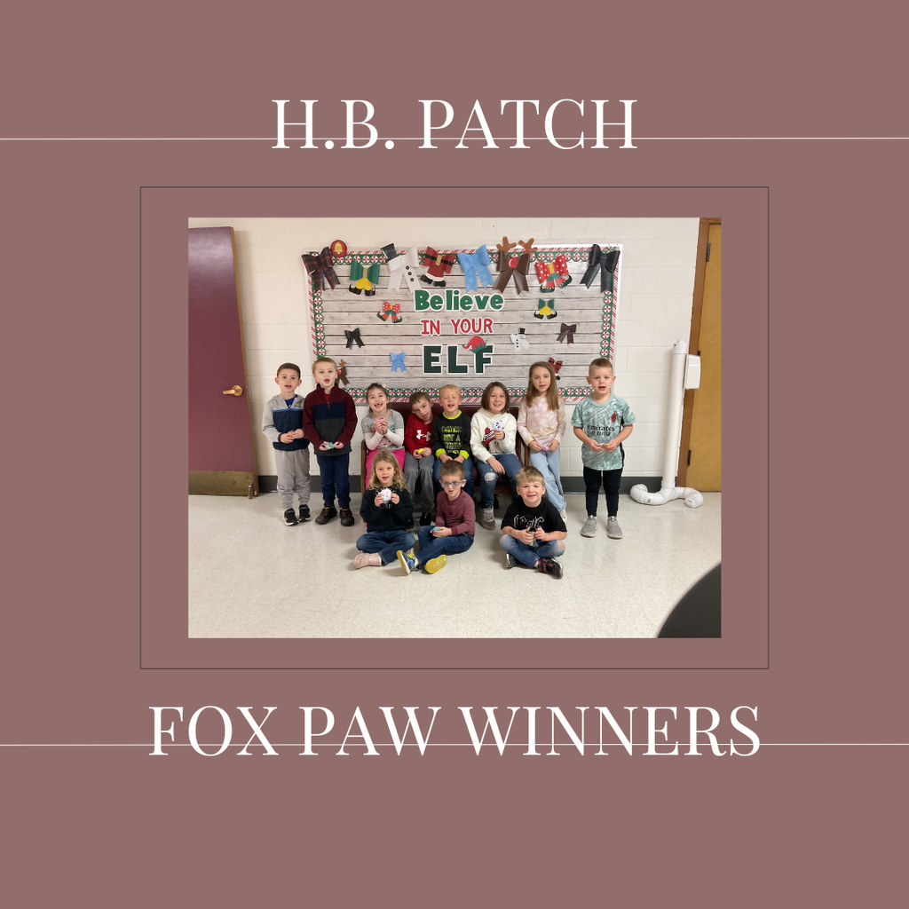 A group of early elementary students standing in front of a bulletin  board.