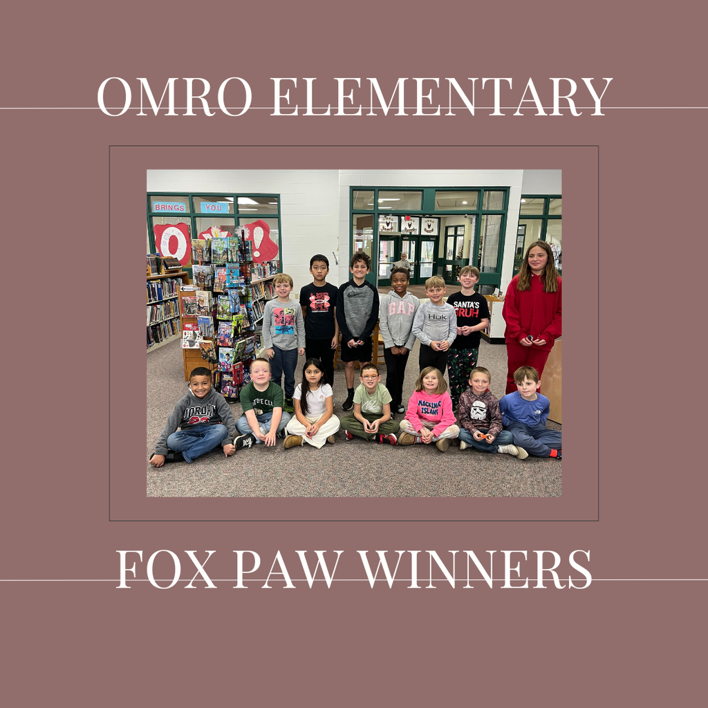A group of elementary students standing in a media center.