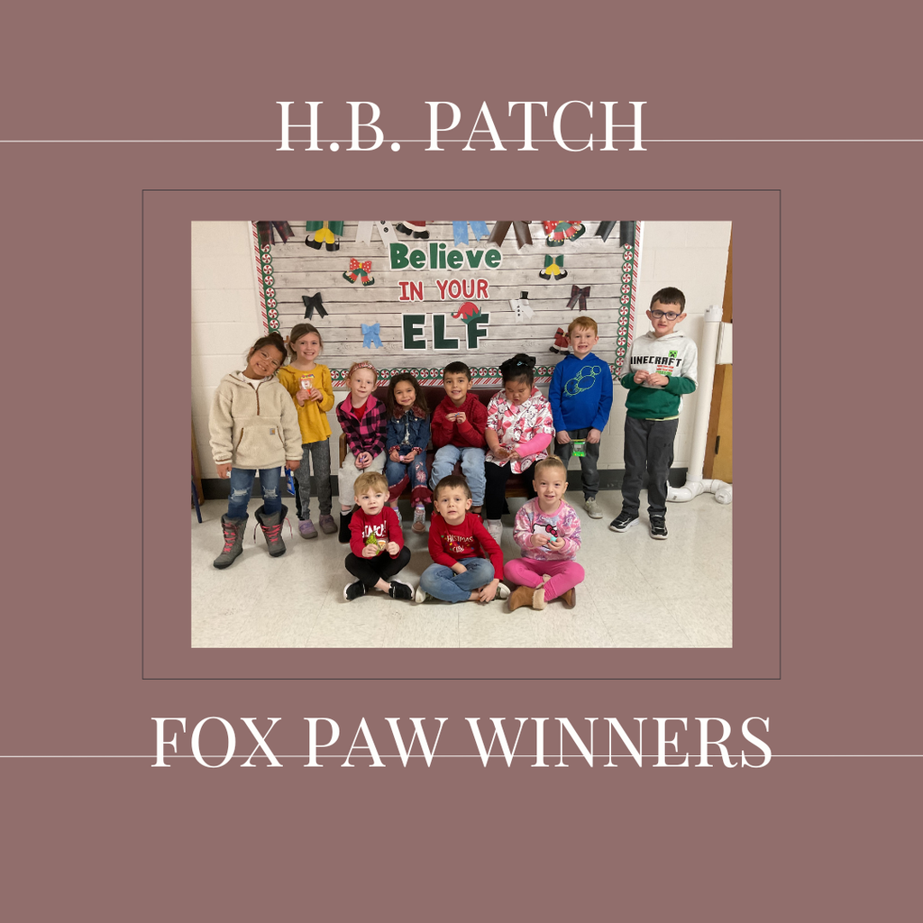 A group of early elementary students standing in front of a bulletin  board.