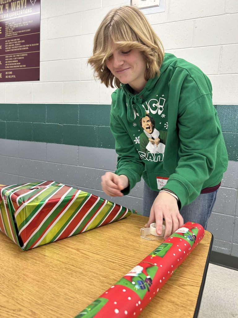 A high school student wrapping presents.