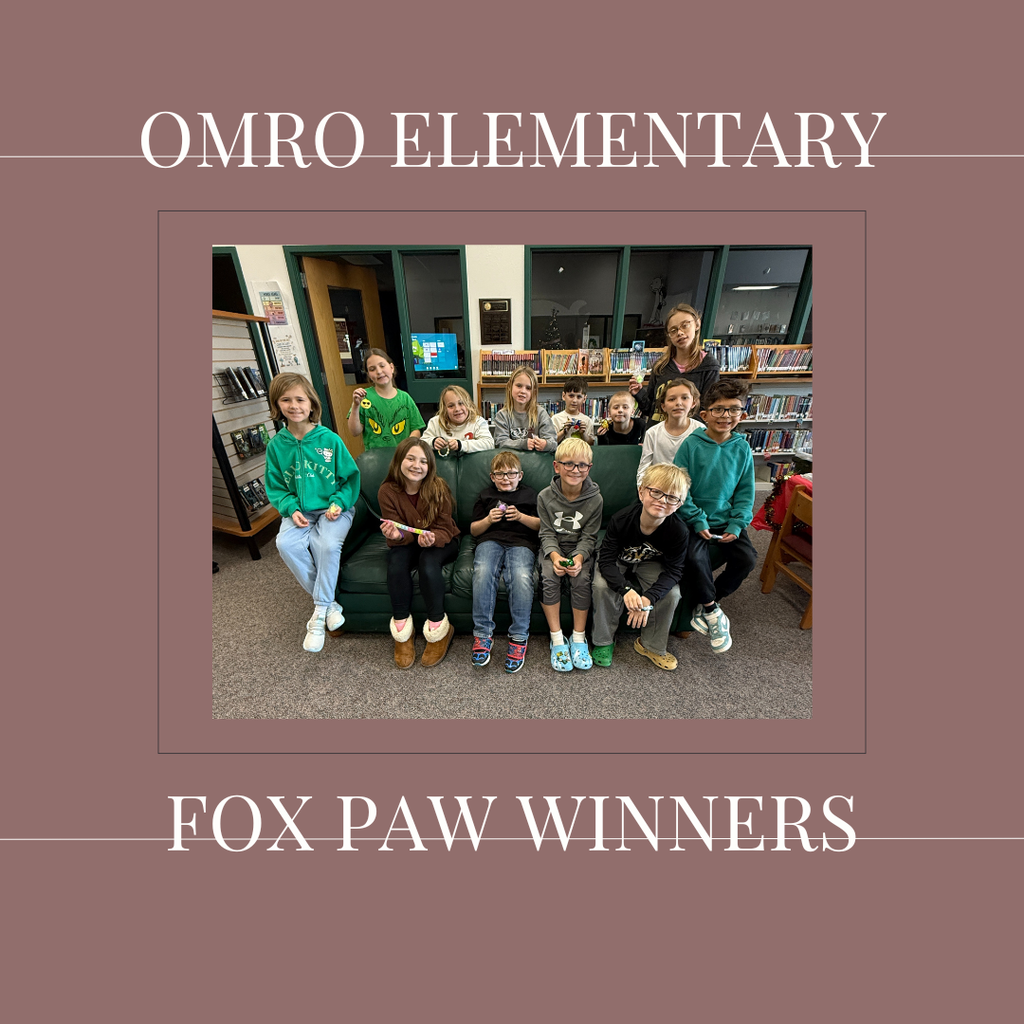 A group of elementary students standing in a media center.