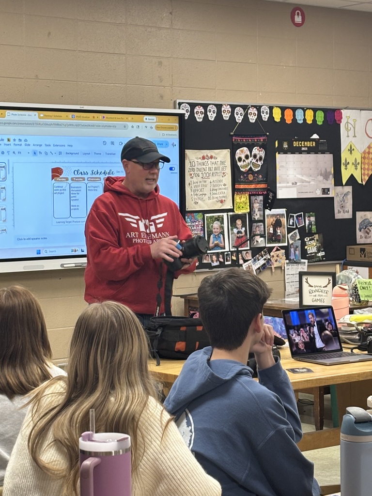 A photographer speaking to a group of high school students.