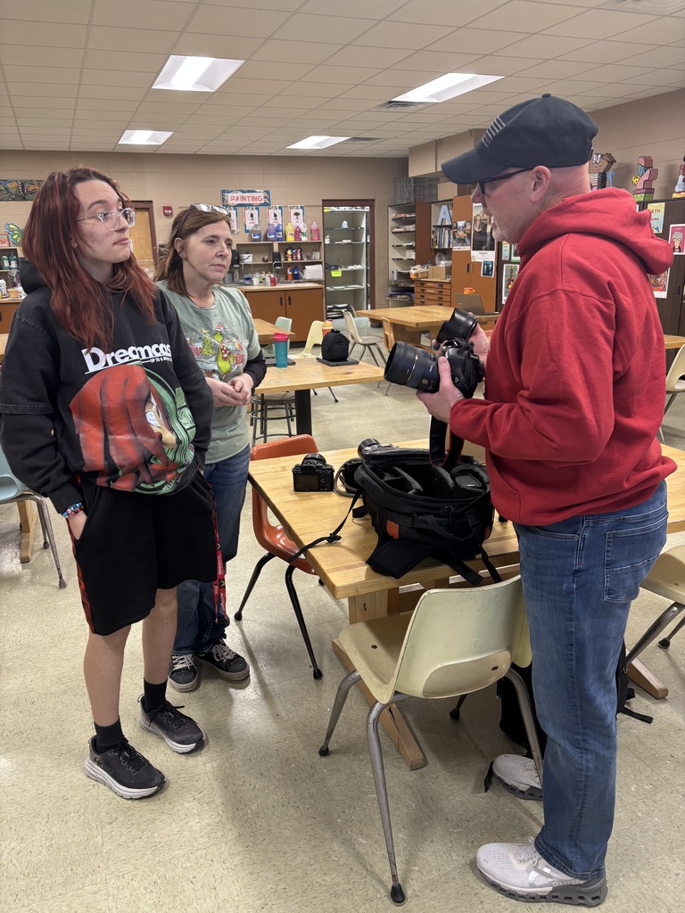 A photographer speaking to a high school student and employee.