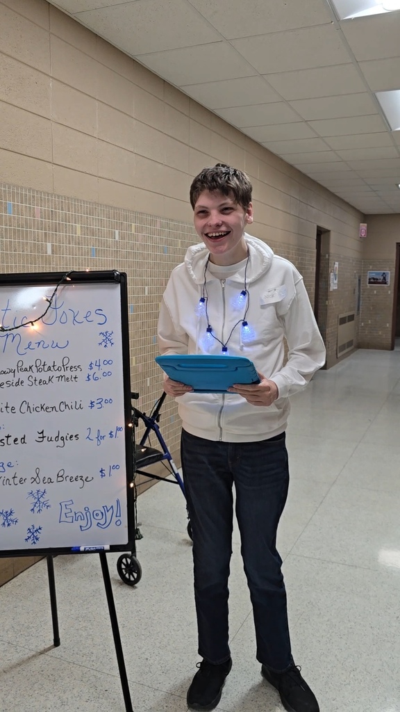 High school student greeting patrons at their food restaurant.
