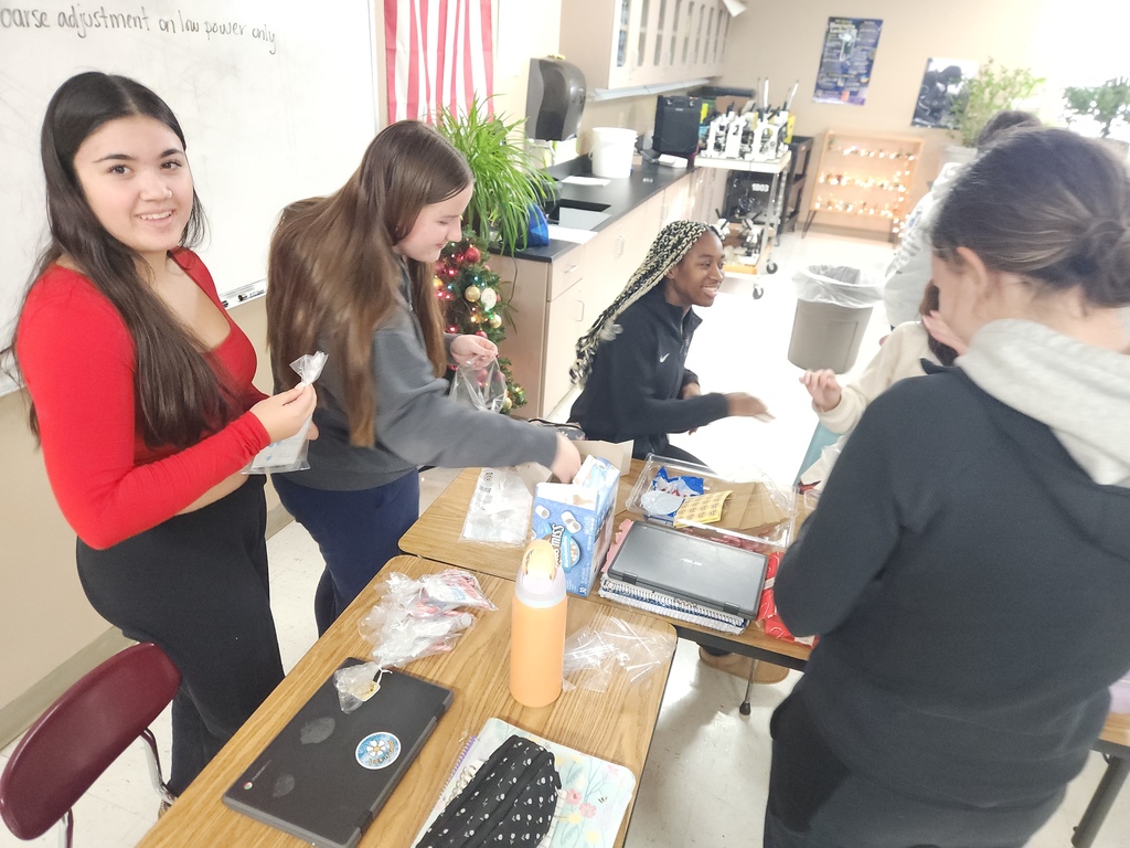 Four high school students preparing gift bags.
