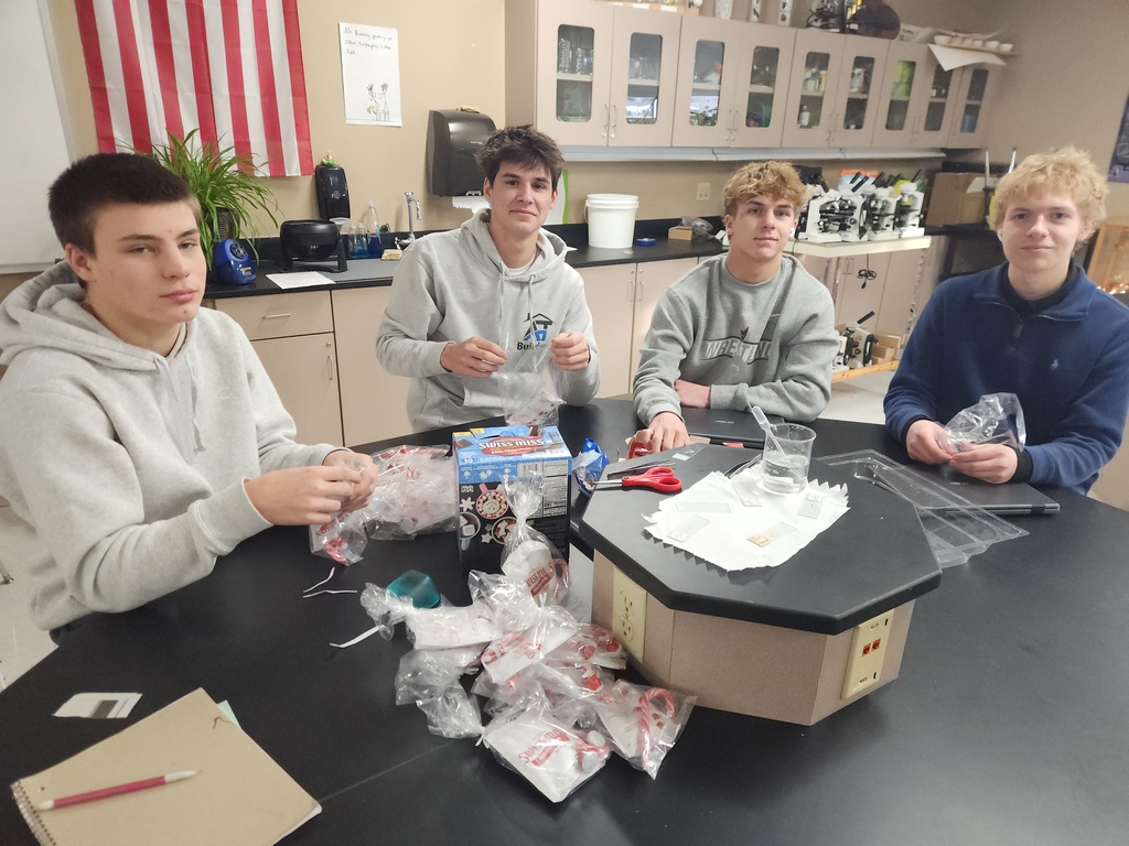 Four high school students preparing gift bags.
