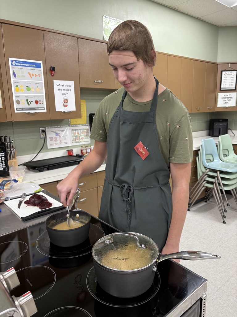 High school student preparing food on a stove.