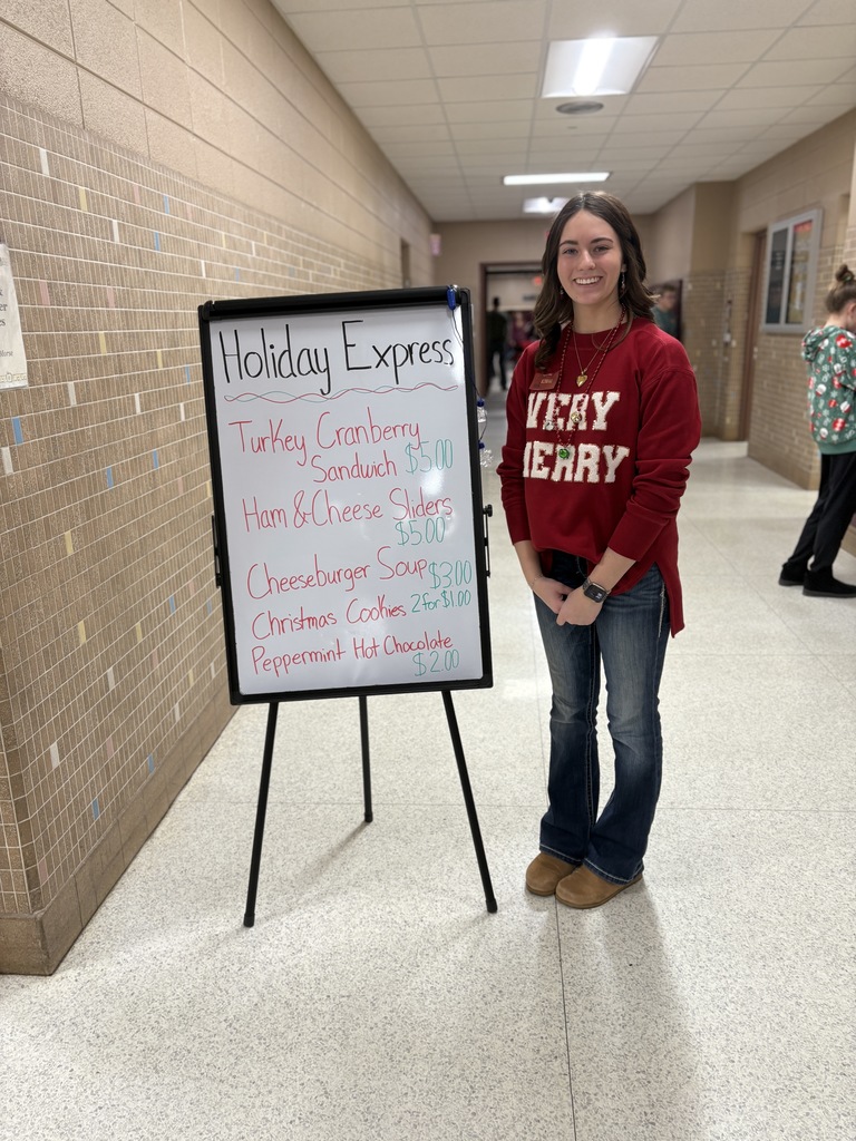 High school student standing near the food menu board.