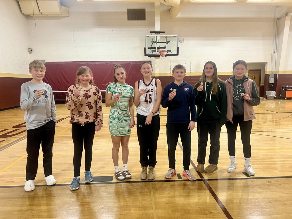 A group of middle school students in a line, holding a "chip" for free ice cream or pizza.