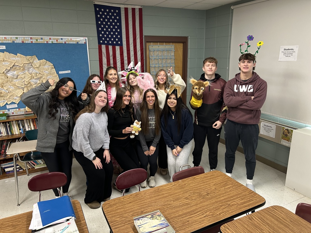 A group of high school students posing together with funny objects.