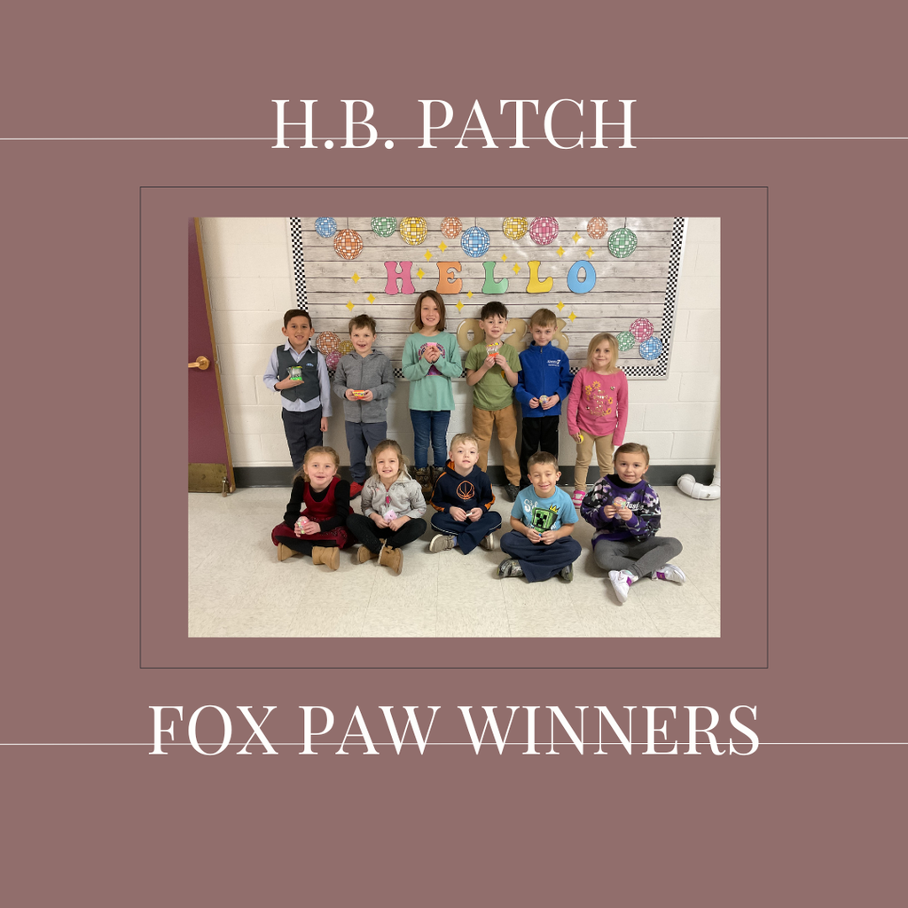 A group of early elementary students standing in front of a bulletin board.