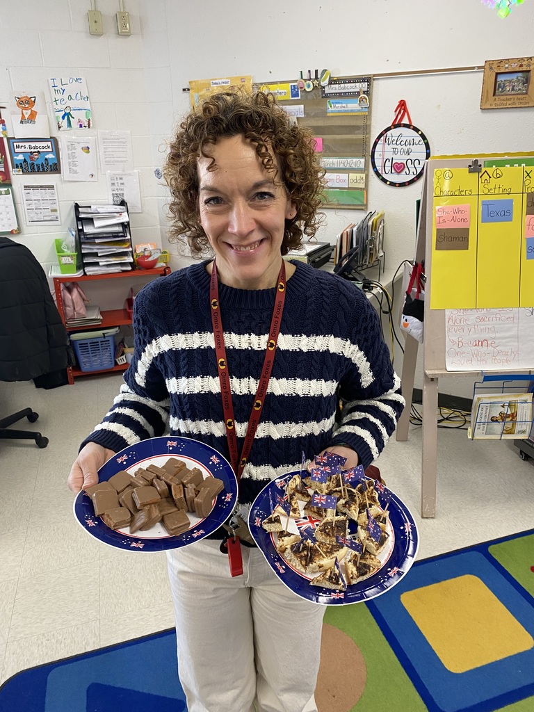 Elementary teacher holding plates of treats.