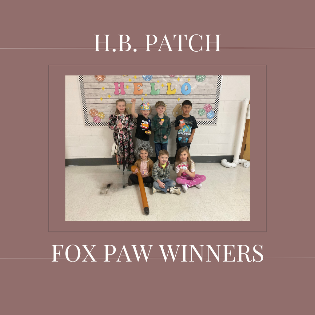 A group of early elementary students standing in front of a bulletin  board.