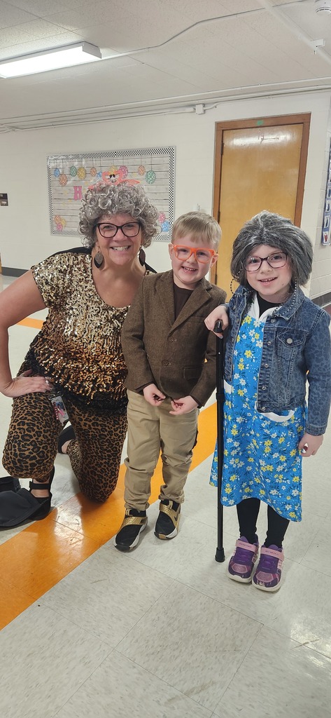 A teacher with two early elementary students dressed as 100  year old people. 