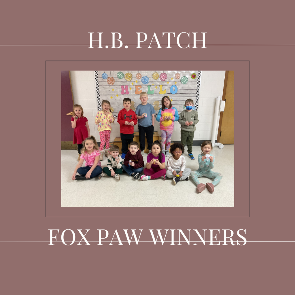 A group of early elementary students standing in front of a bulletin  board.