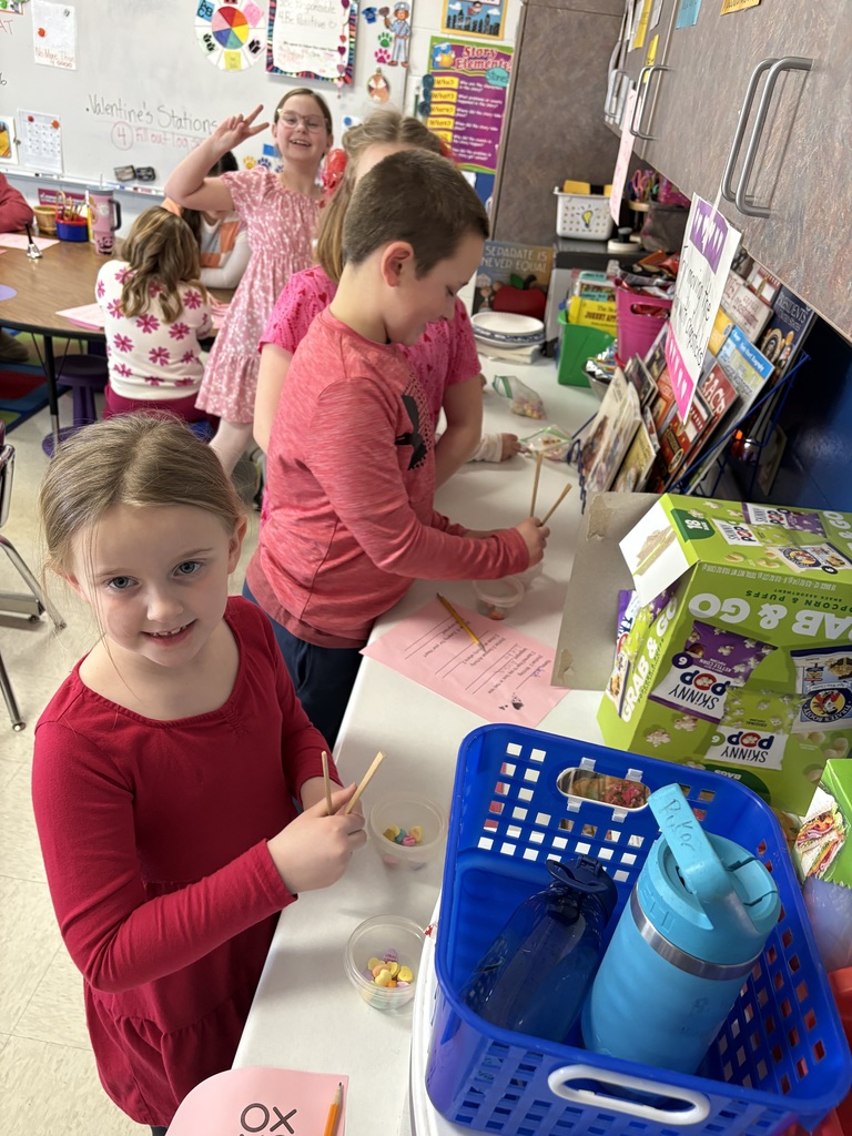 Students lined up at a counter practicing using chopsticks.